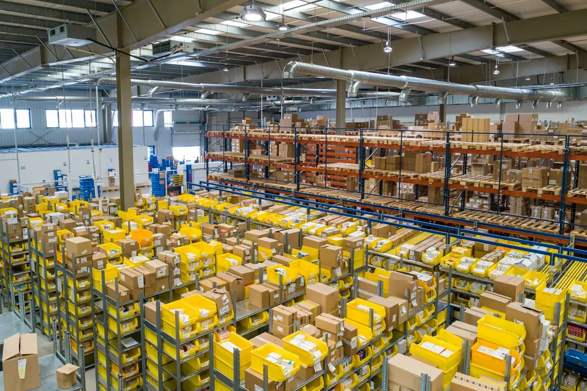 Centro de distribuição com caixas e fluxo logístico organizado.